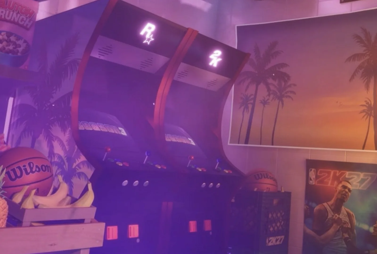 Two Rockstar-branded arcade cabinets in a GTA 6 store corner beside palm-tree wall art and an NBA 2K27 poster.