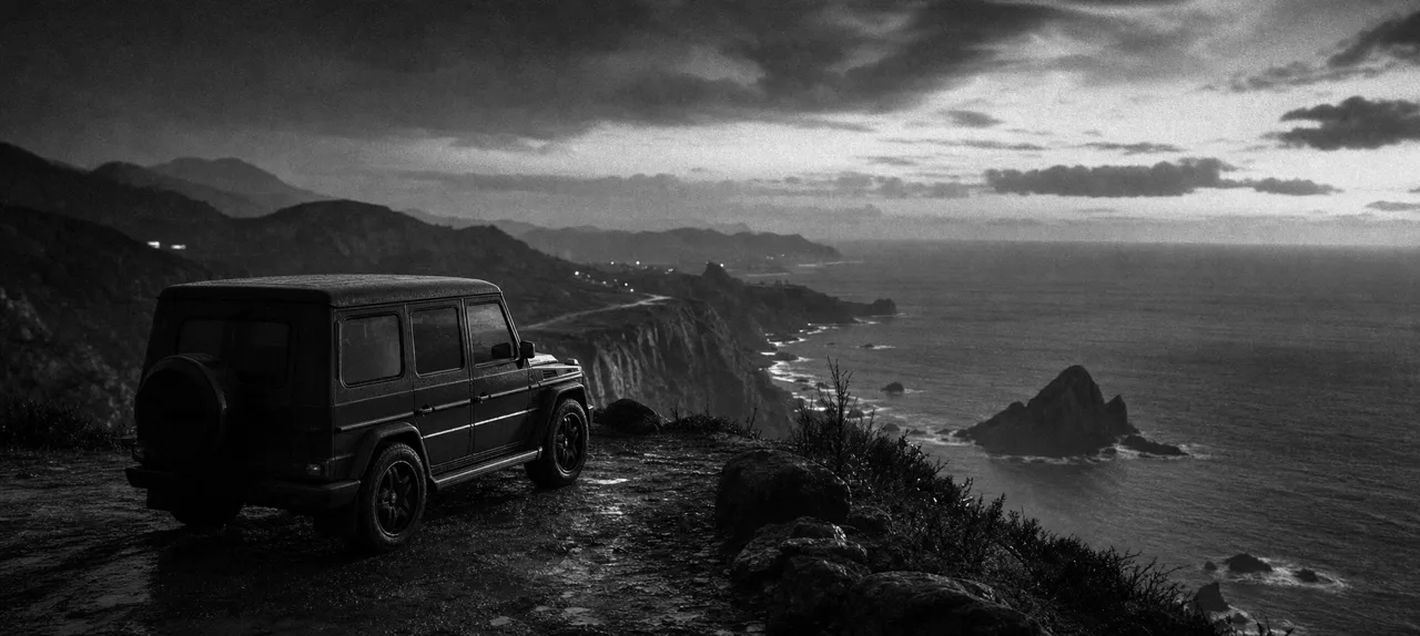 Black and white cinematic concept image of a boxy luxury off-road SUV parked on a coastal cliff overlook at dusk