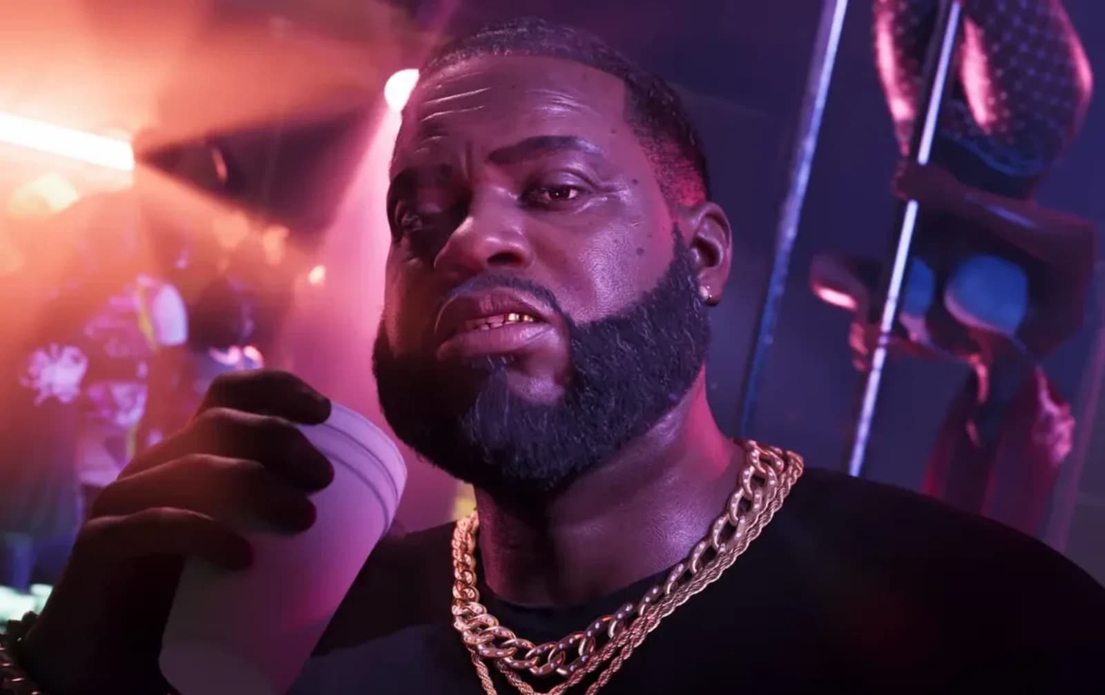 Boobie Ike standing outside the Jack of Hearts adult entertainment club at night, wearing a cream knit shirt and a heavy gold chain, holding a phone.