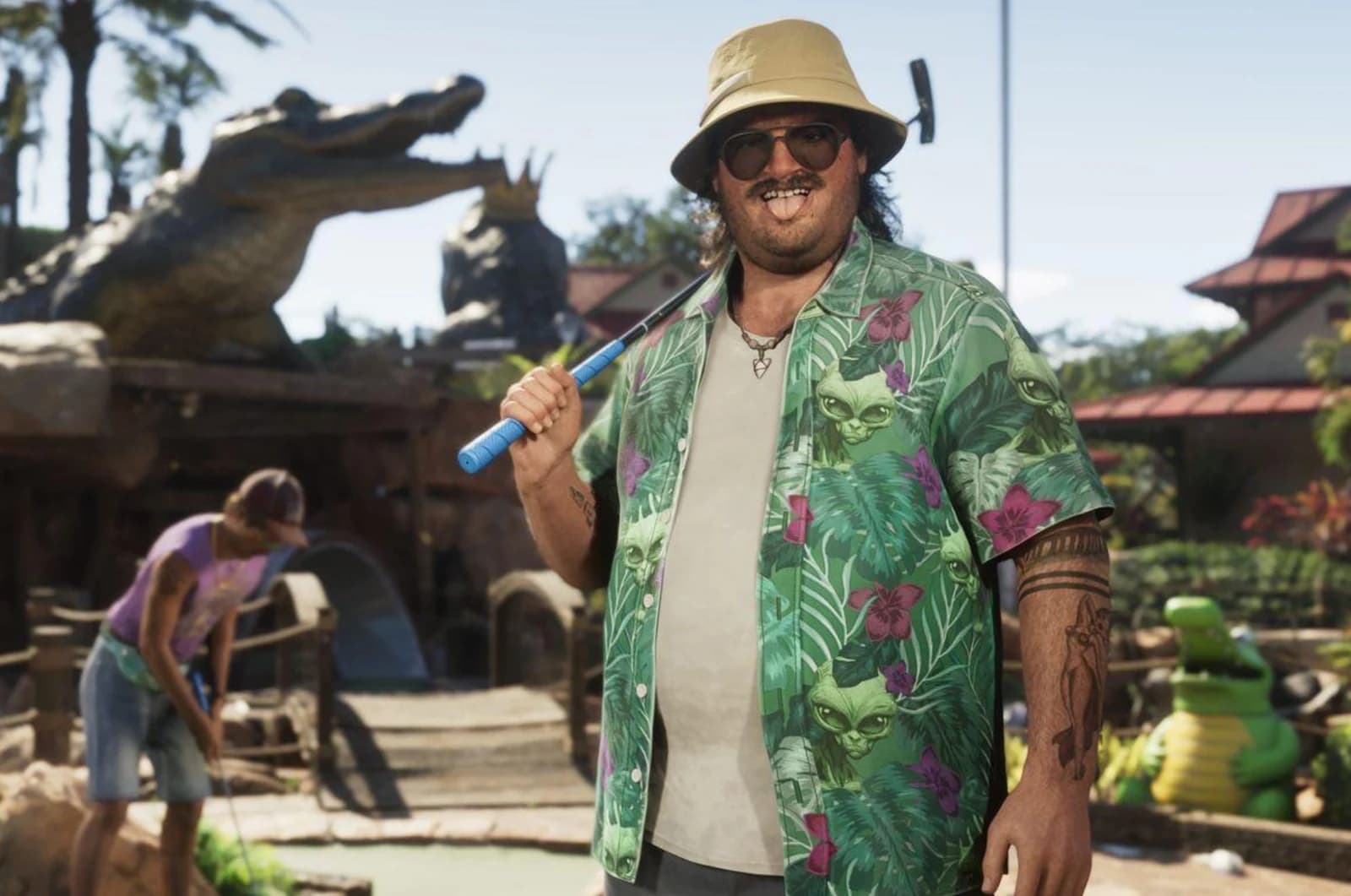 Cal Hampton at a tropical mini-golf course, wearing a green floral shirt and a beige bucket hat, holding a putter over his shoulder.