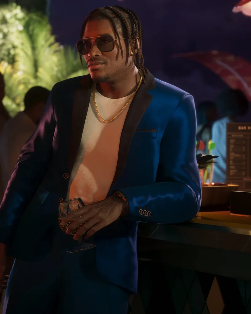 Dre'Quan Priest in a midnight-blue blazer at the Mai Dreams pool party, holding a cocktail, leaning on a bar.