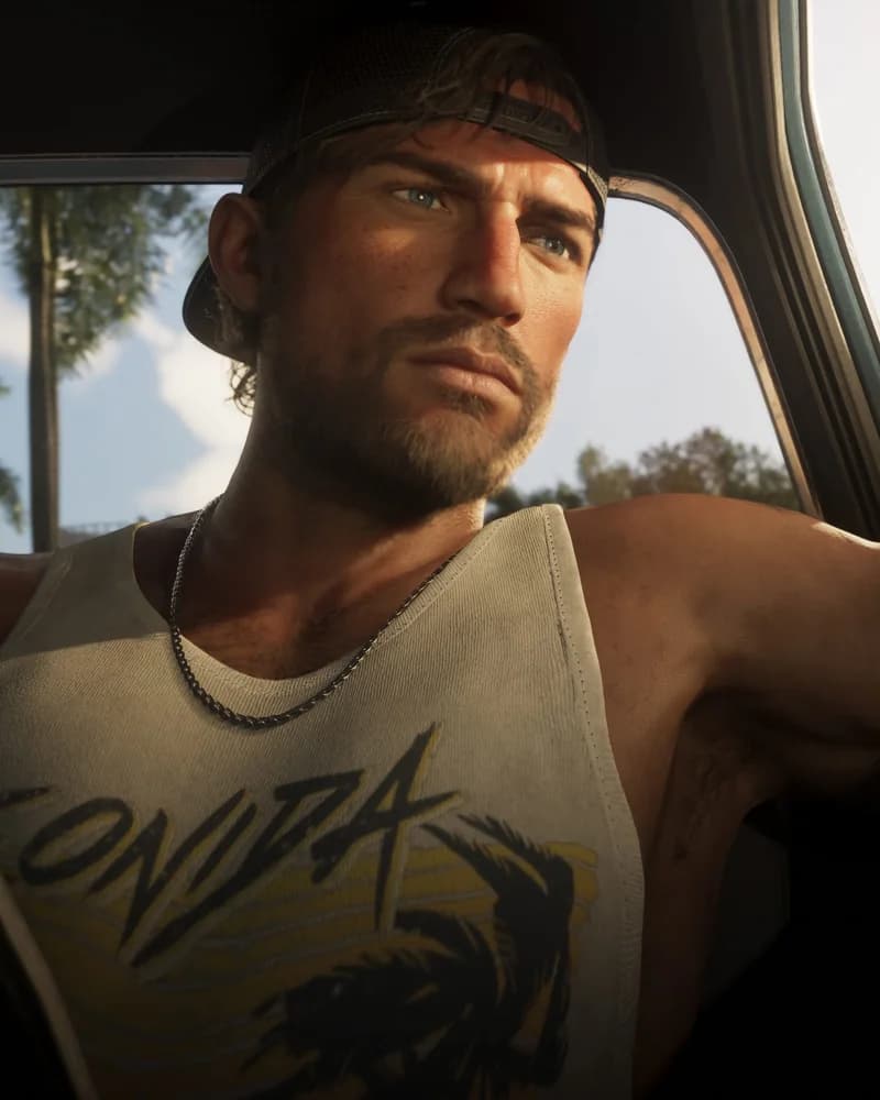 Jason Duval seated in a car, wearing a white Leonida Marine Centre tank top and a backwards baseball cap, palm trees visible through the window.
