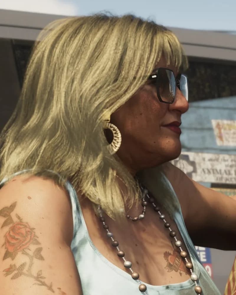 Lori Heder leaning out of a car window in Trailer 2, blonde hair and oversized sunglasses, rose tattoo on her shoulder.