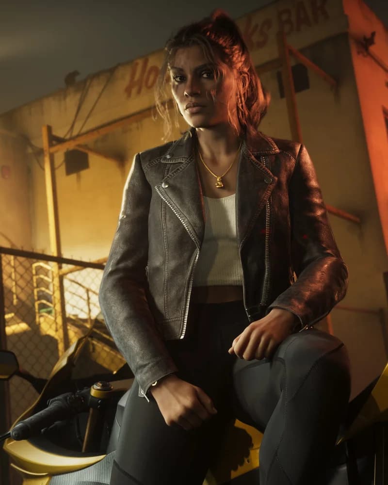 Lucia Caminos sitting on a motorcycle outside a Vice City liquor bar at night, wearing a brown leather jacket.