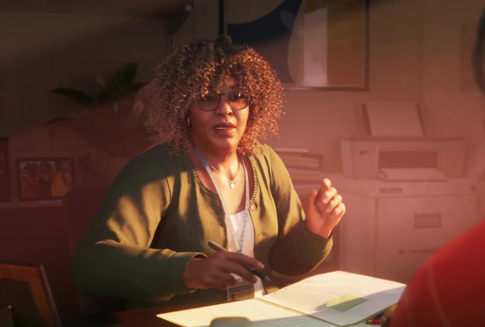 Stefanie G. seated across a desk from Lucia at the Leonida correctional facility, glasses and curly hair, lit warmly.