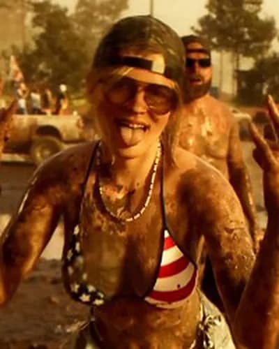 Woman covered in mud cheering at the Thrillbilly mud festival, Trailer 2.