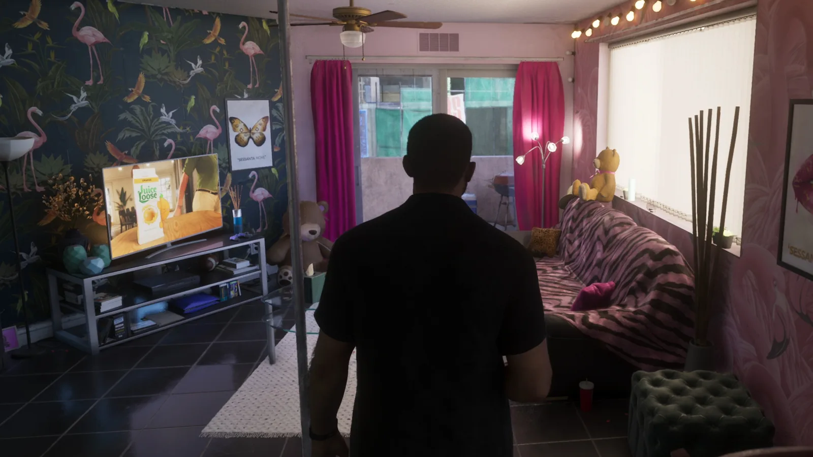 A character stands in a flamingo-wallpapered room watching a wall-mounted TV in GTA 6