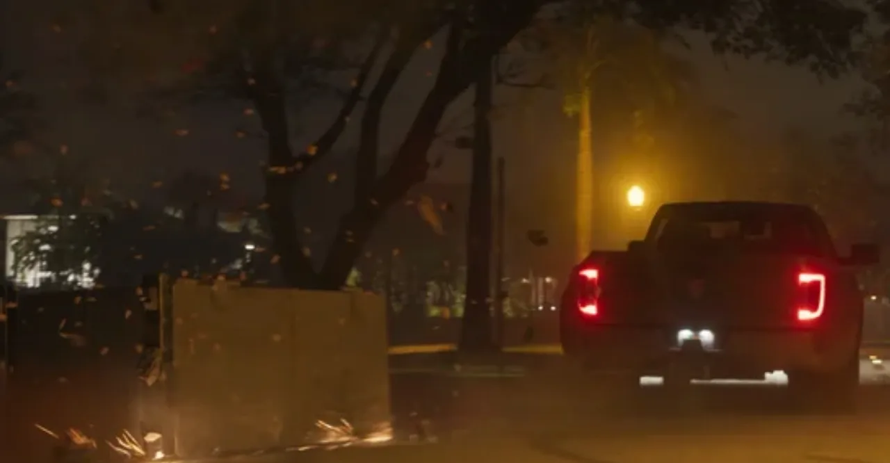 A vault being dragged behind a pickup truck at night with sparks flying, from the GTA 6 trailer