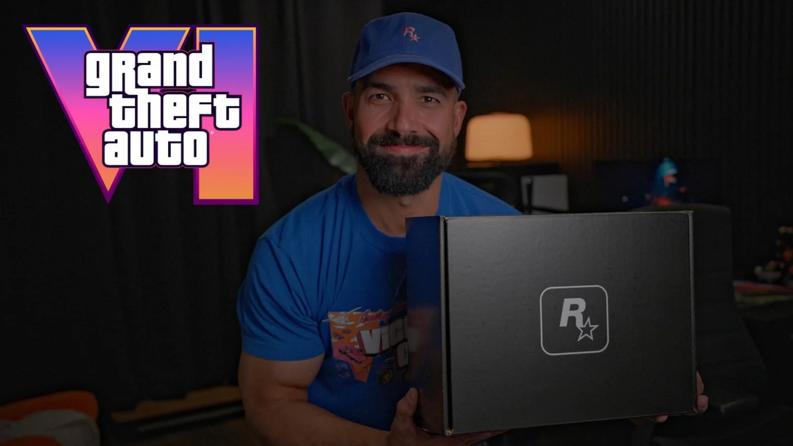 TmarTn holds the black Rockstar care package box beside the Grand Theft Auto VI logo