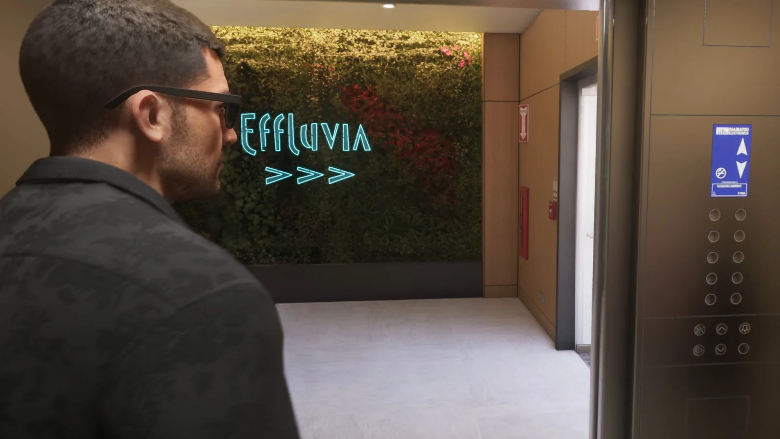 Jason stepping out of the lift towards the Effluvia sign on a living plant wall