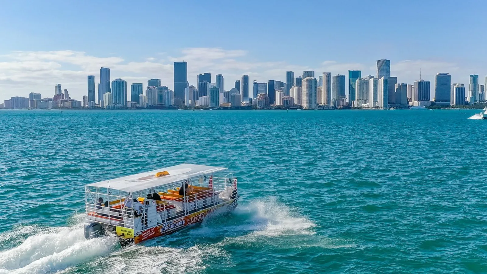 A water taxi crossing the bay in front of the Miami skyline