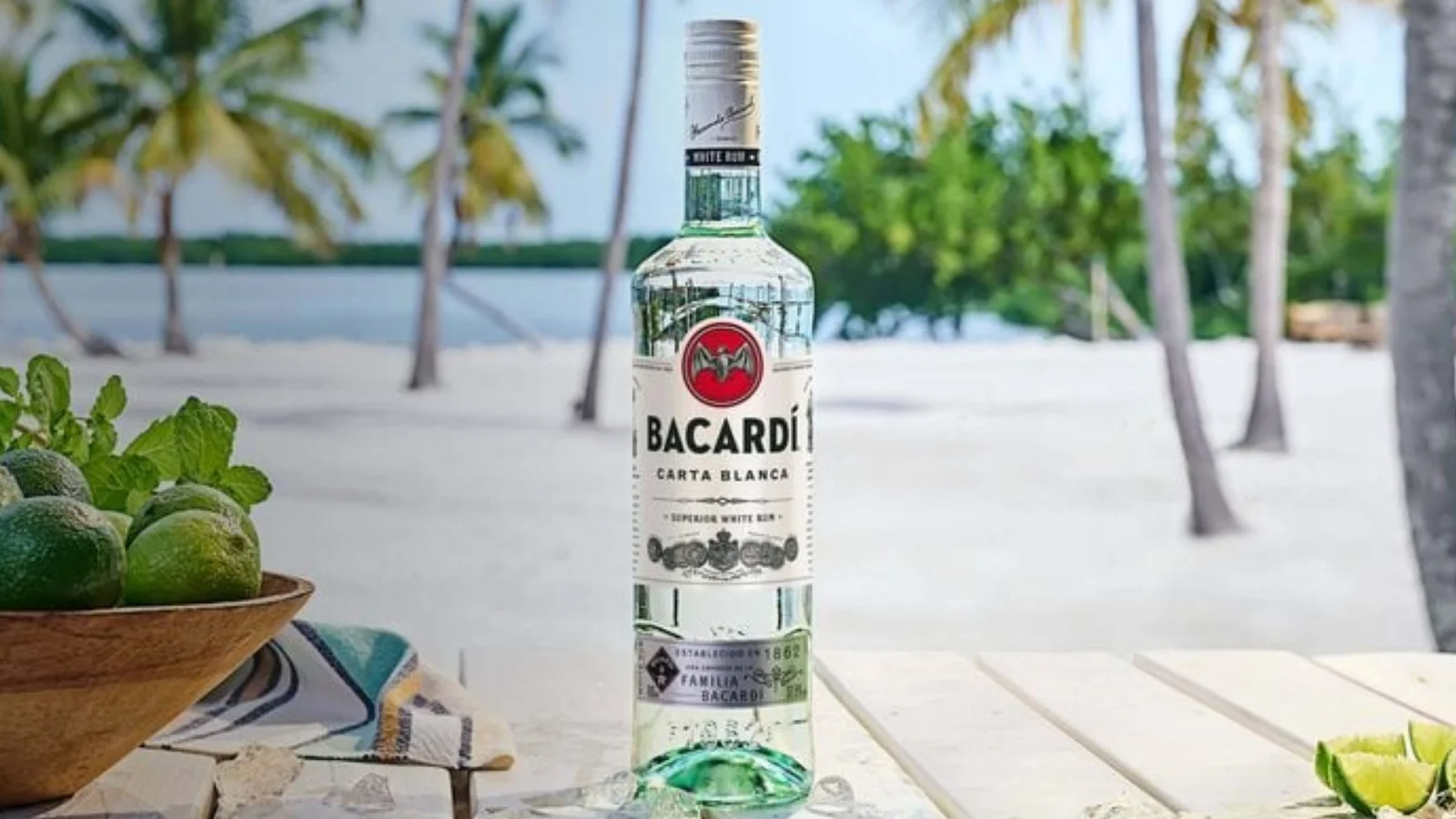 A bottle of Bacardi white rum on a beachside table