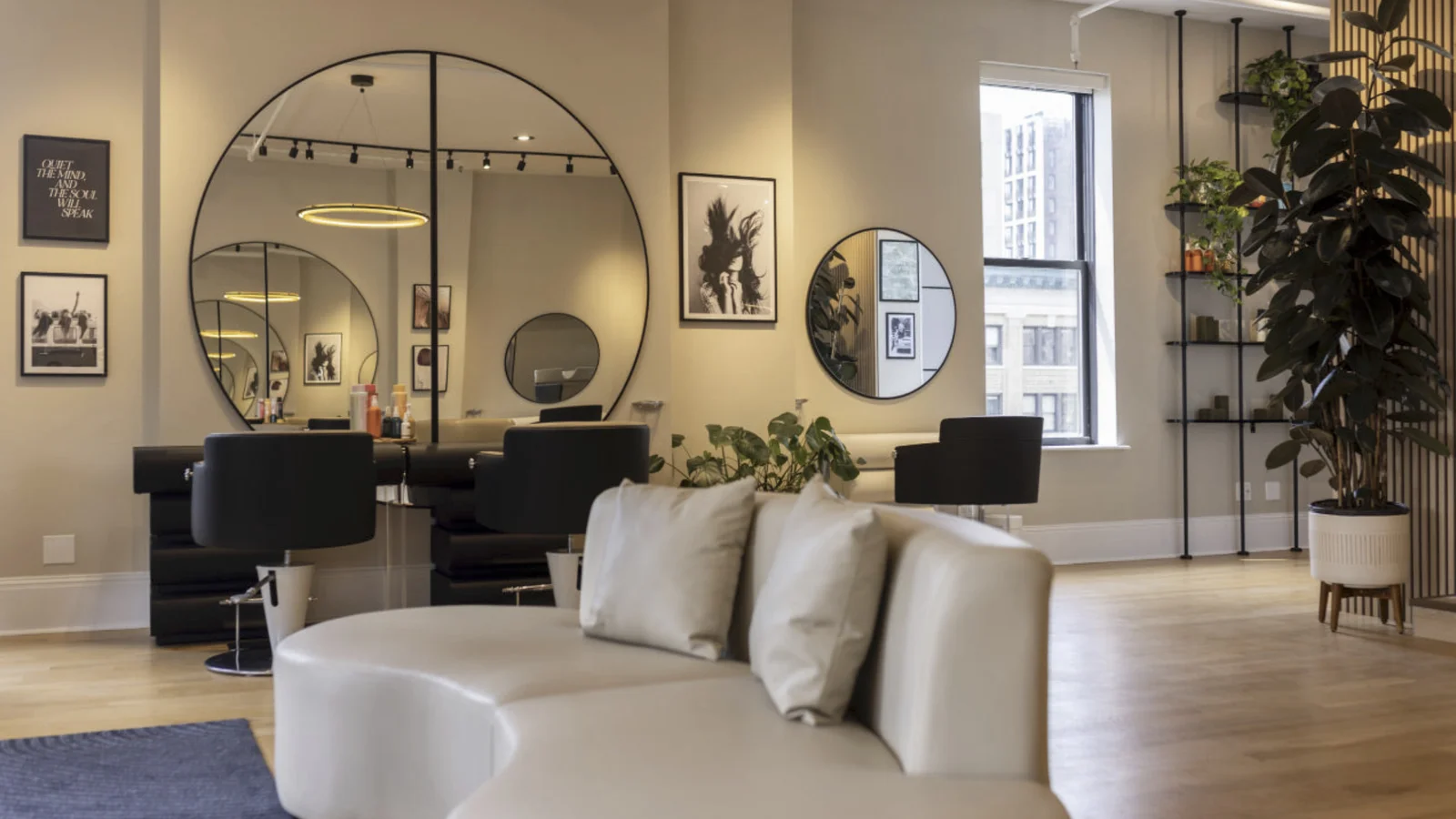 A modern hair salon interior with styling stations and round mirrors