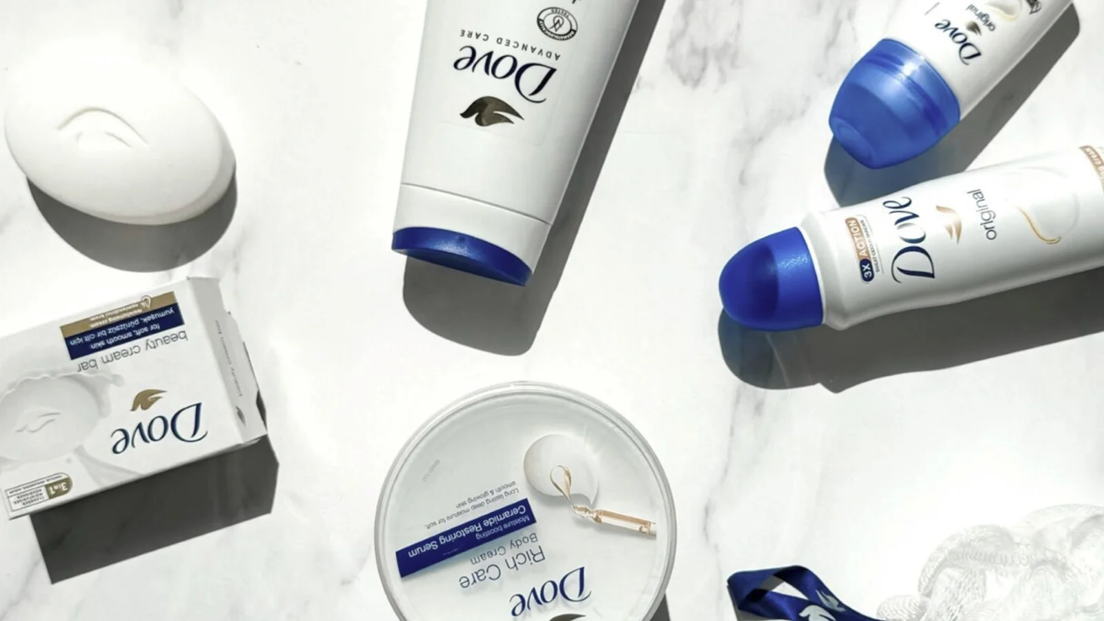 Dove soap, body wash and skincare products laid out on marble
