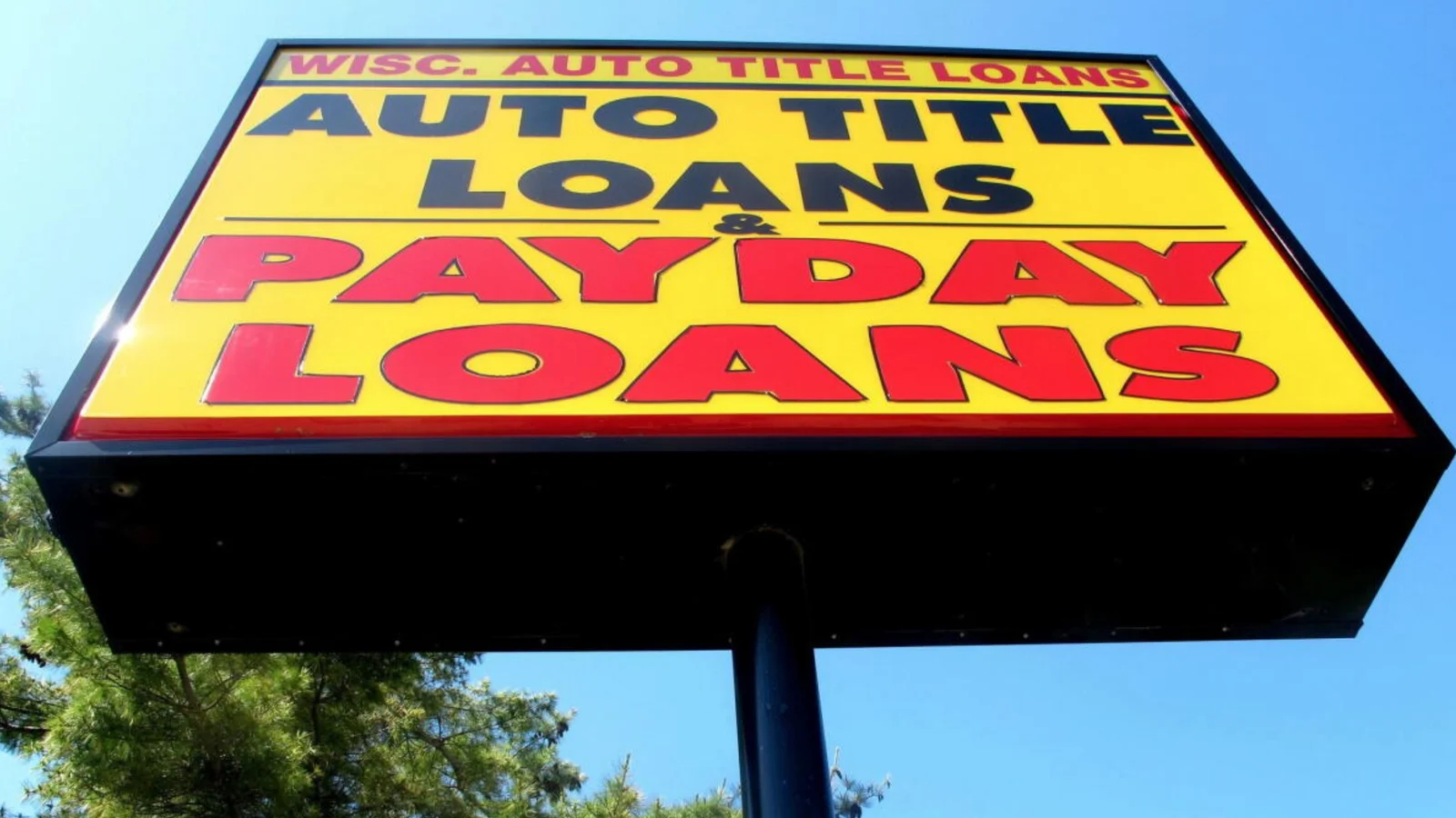 A yellow payday loans sign above a roadside shop