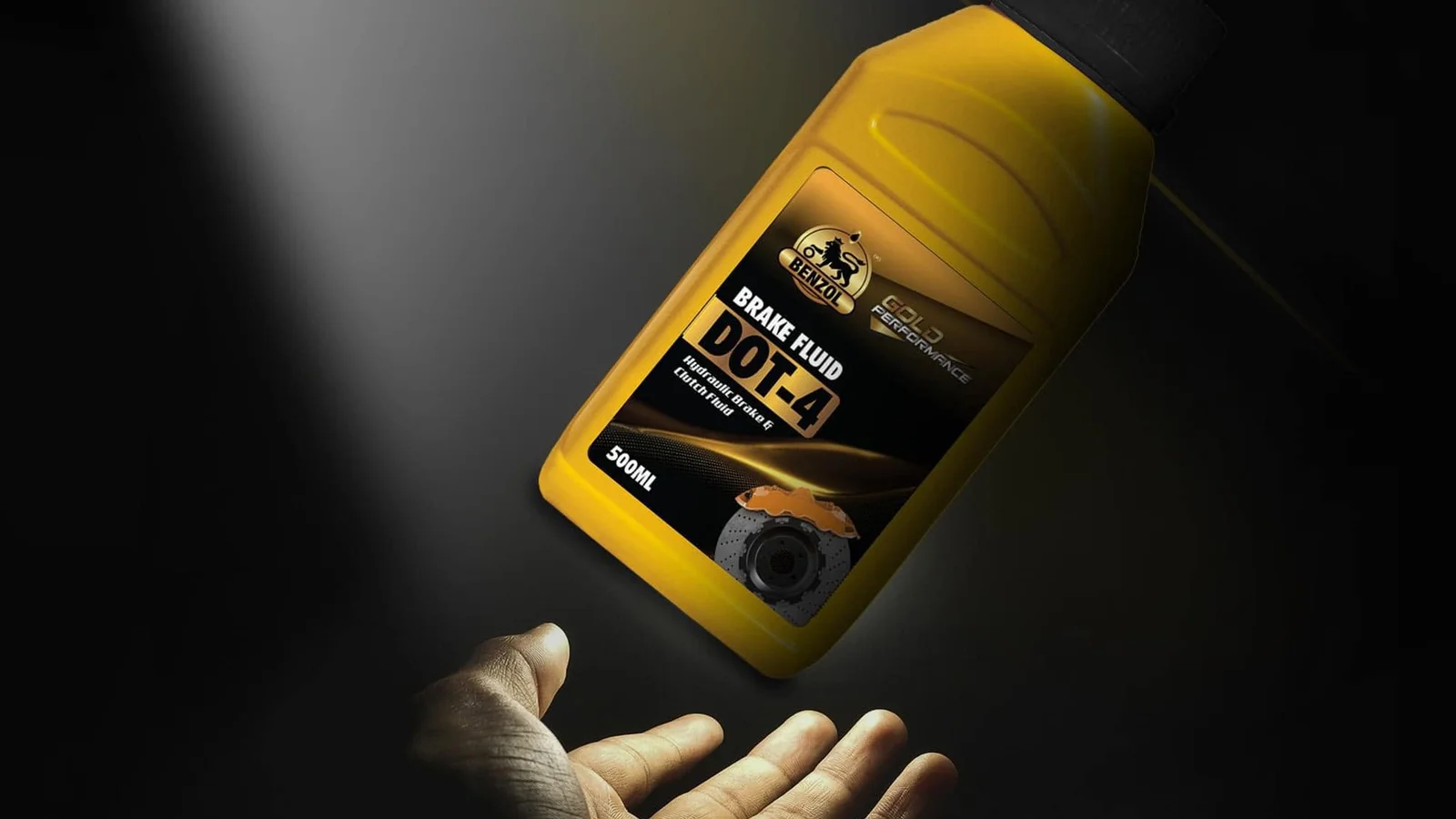A yellow bottle of brake fluid held in an outstretched hand