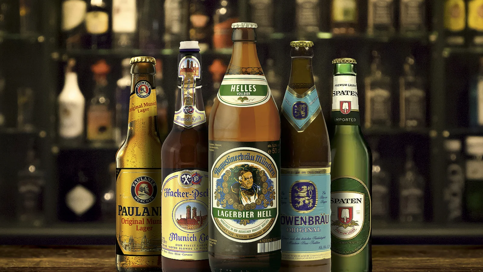 A row of German helles lager bottles on a bar shelf