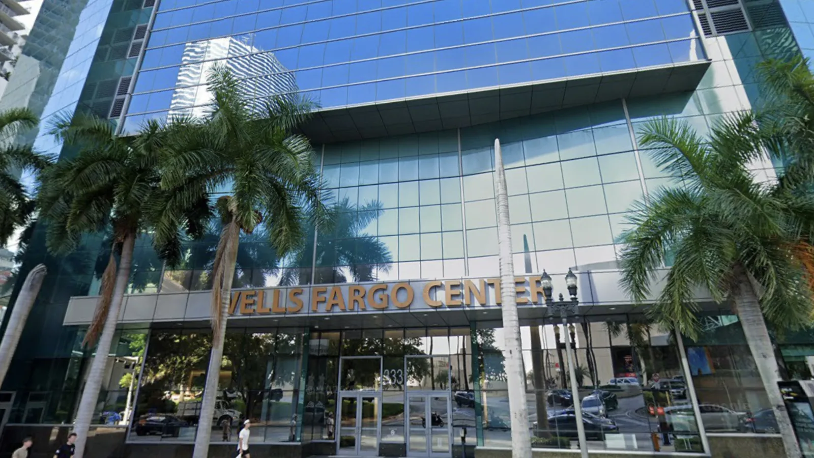 A banking tower entrance framed by palm trees