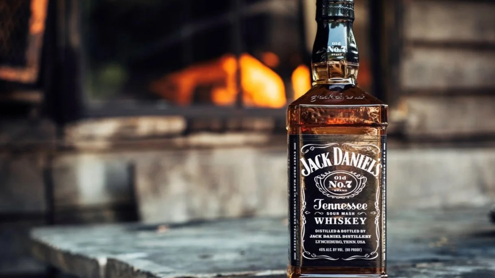 A bottle of Jack Daniel’s Tennessee whiskey by a fire