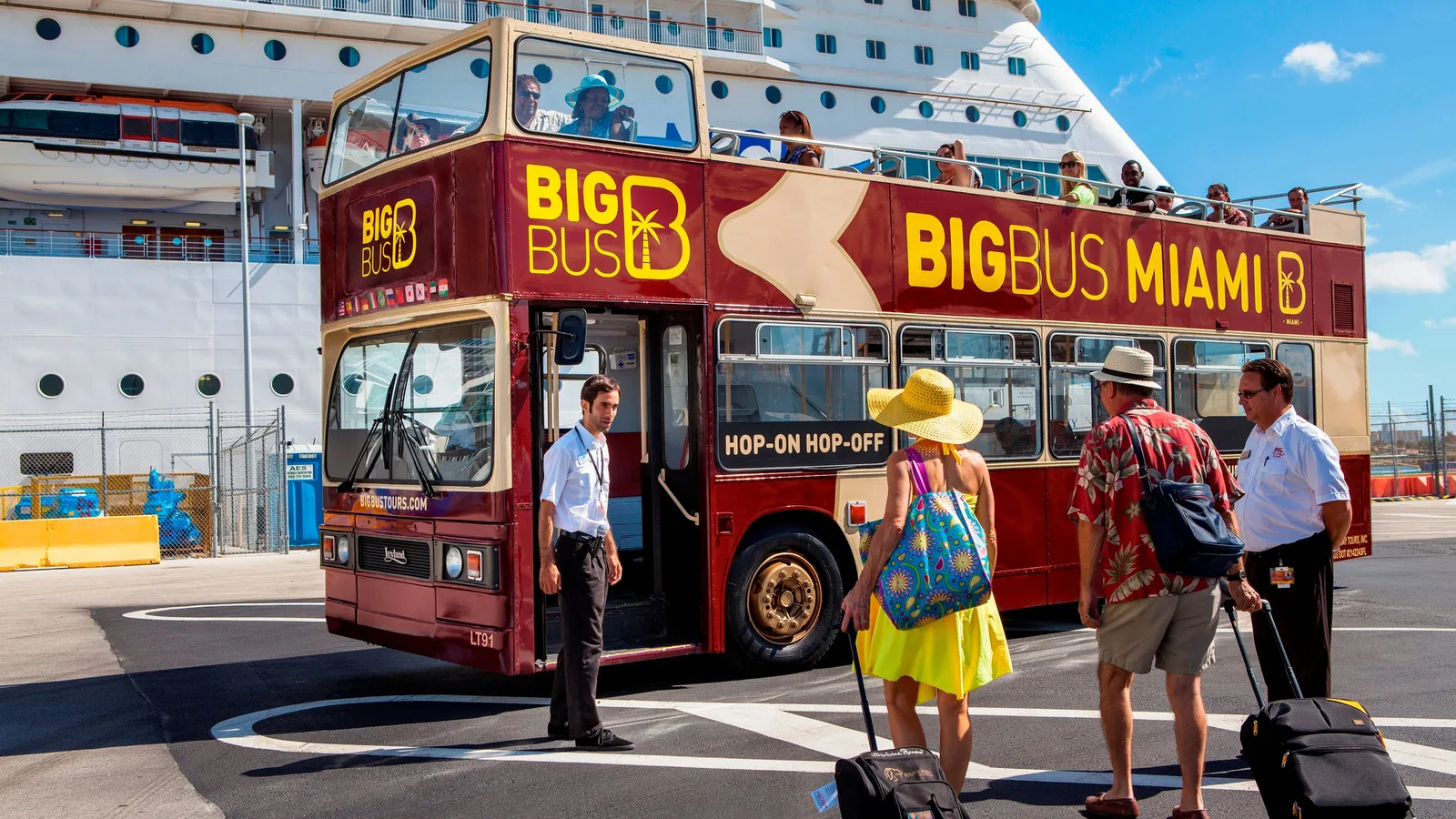 Tourists boarding a red open top sightseeing bus at the cruise port
