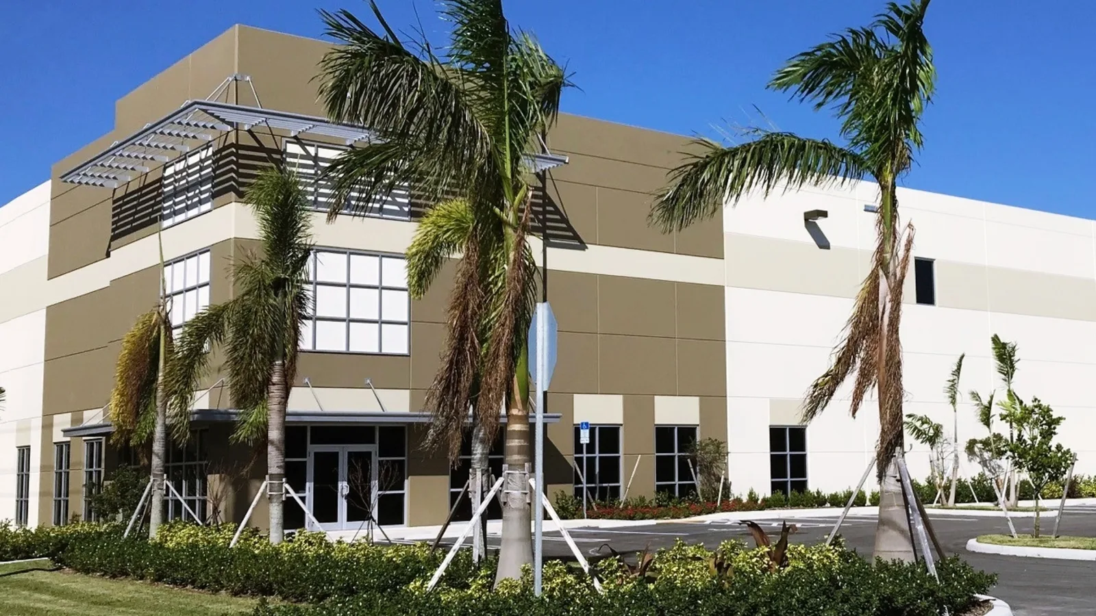A low corporate building behind palms at a food company campus
