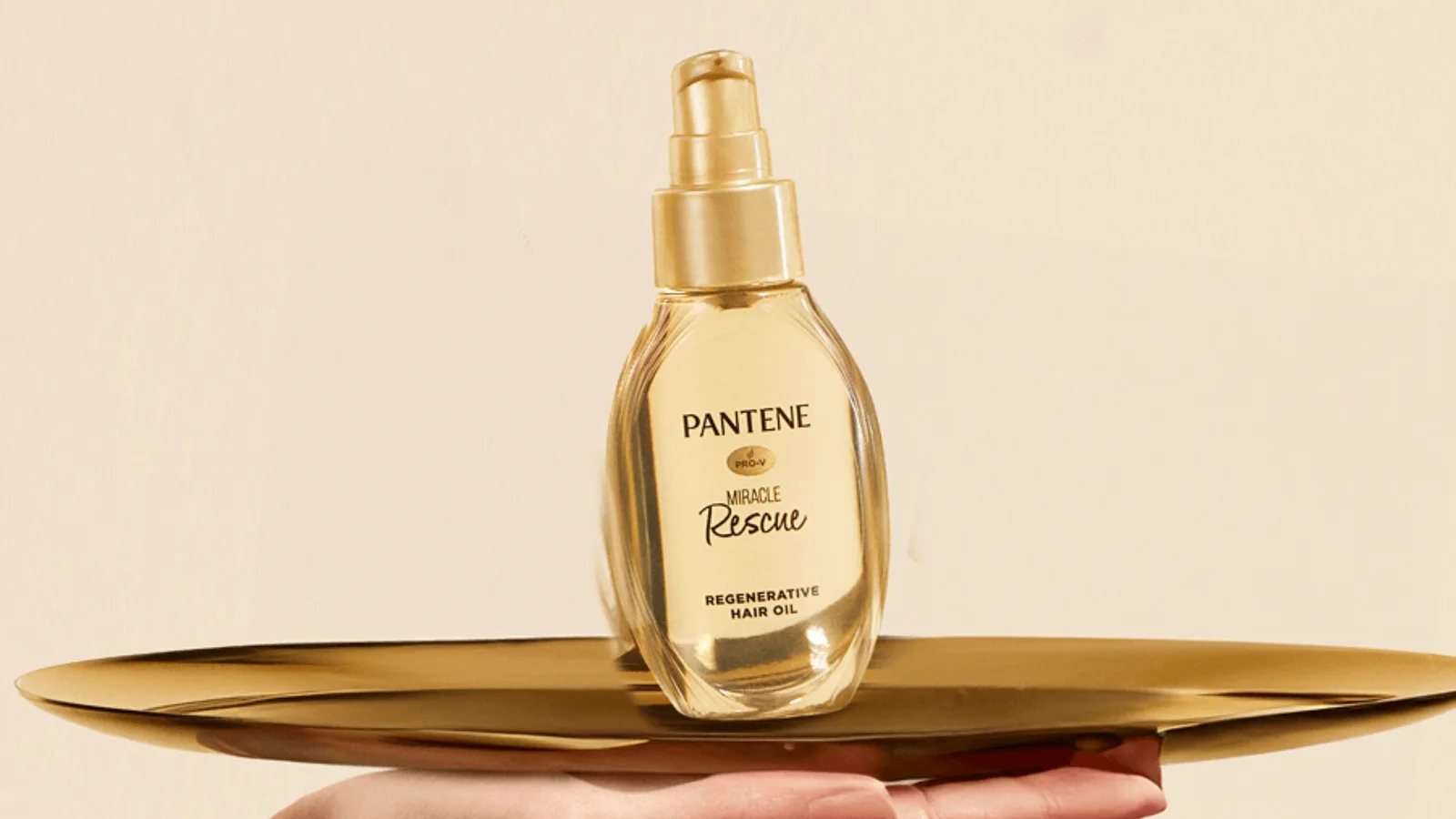 A gold Pantene Miracle Rescue bottle presented on a tray