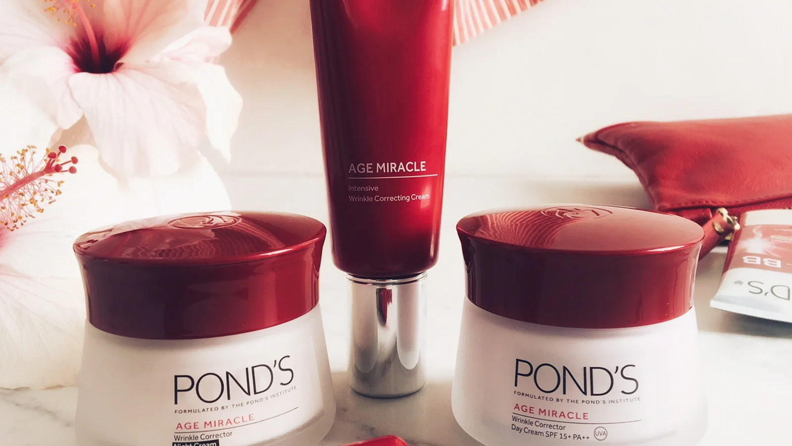 Pond’s Age Miracle jars and tubes in a red and white flat lay