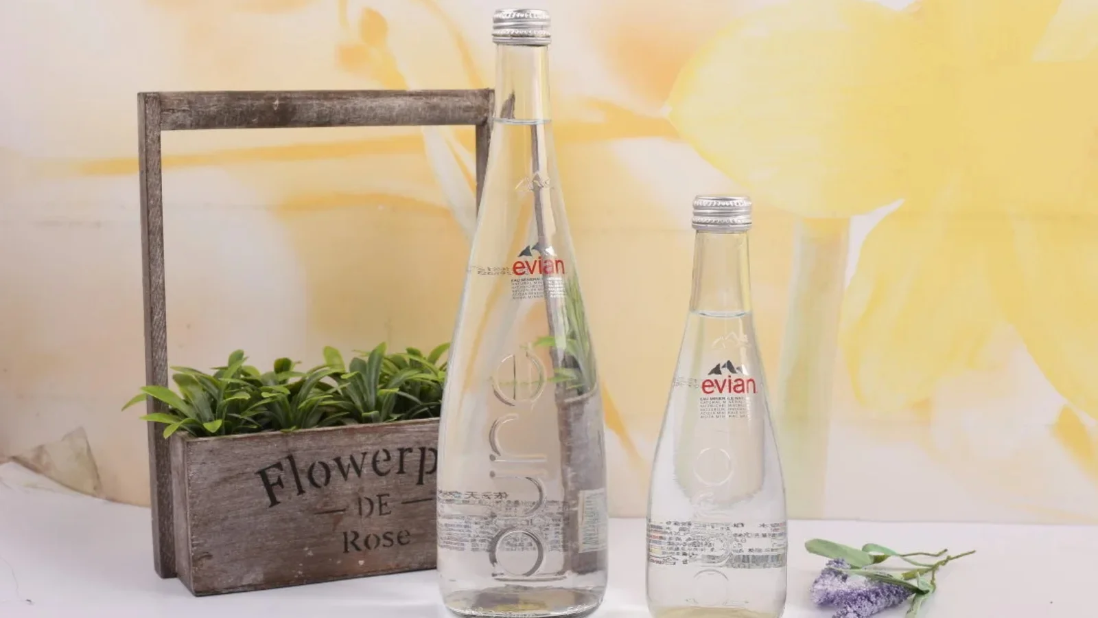 Evian glass bottles on a rustic windowsill display