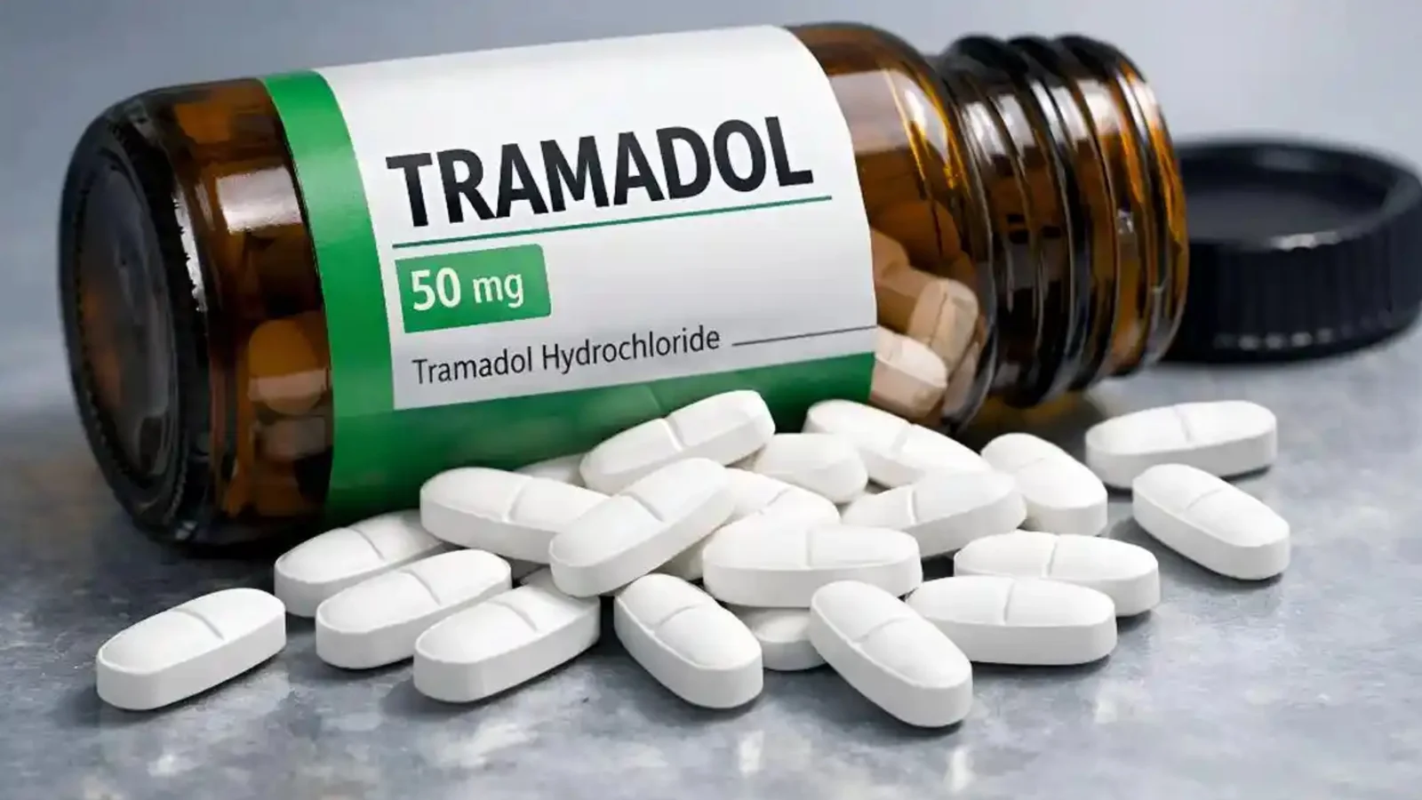 A Tramadol pill bottle with white tablets spilled beside it