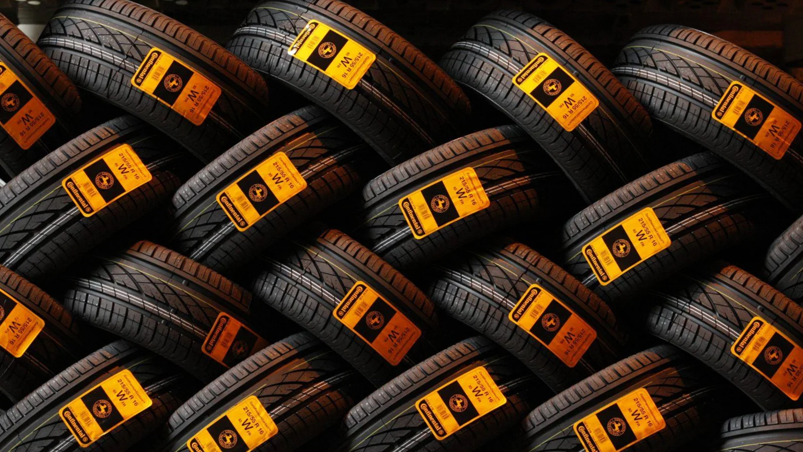 New tyres stacked in rows with yellow spec labels