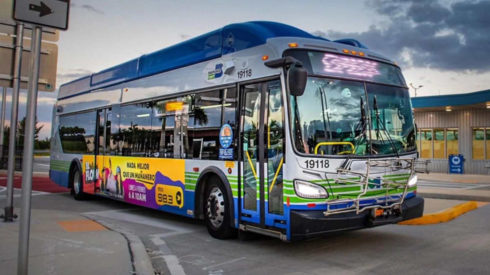 A Miami-Dade Metrobus in a colourful wrap pulling out of a transit station