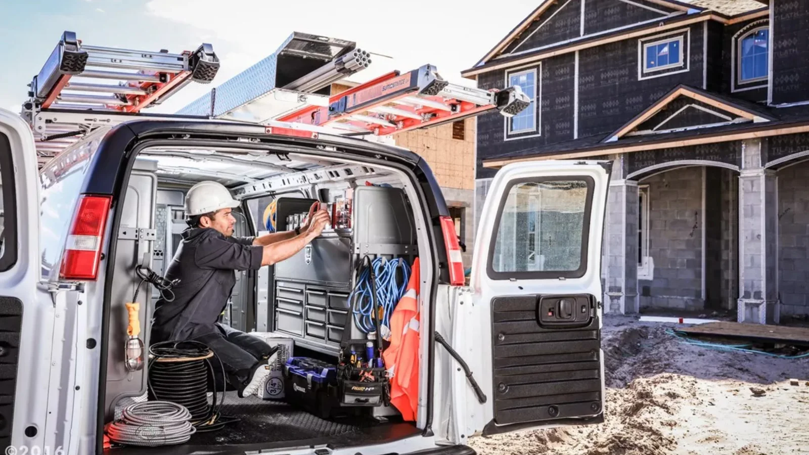 An electrician sorting cables in the back of a work van