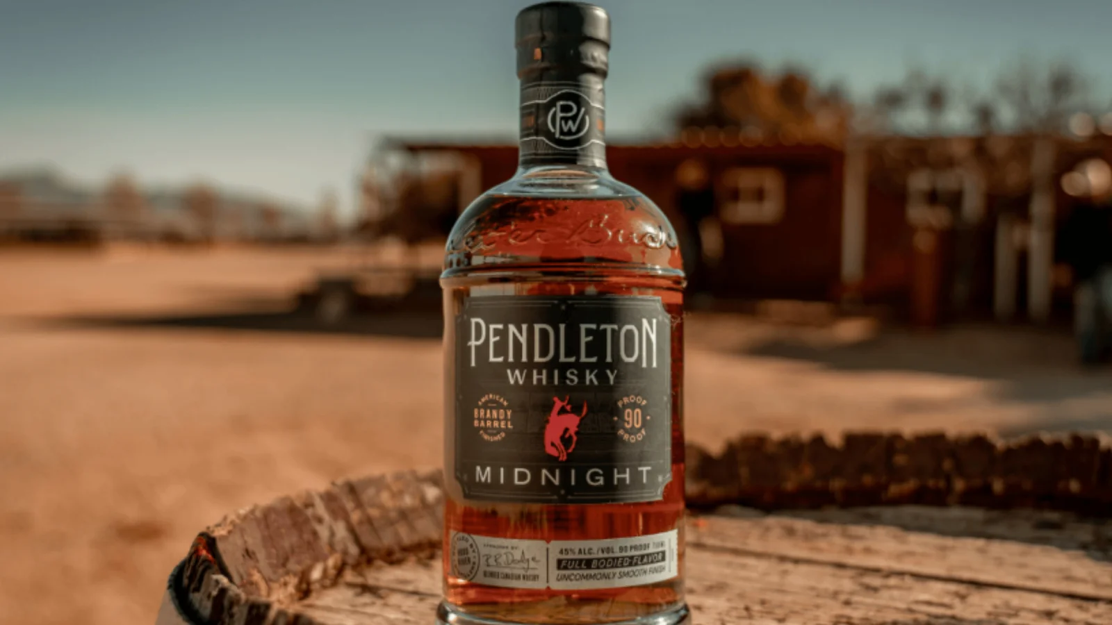 A bottle of Canadian whisky on a rustic wooden stump
