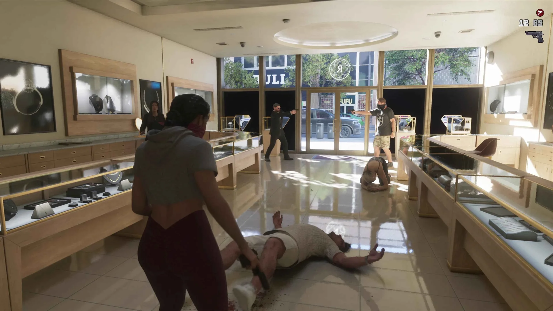 Lucia stands over a man lying on the floor of a bright jewellery store in GTA 6 while armed accomplices cover the entrance.
