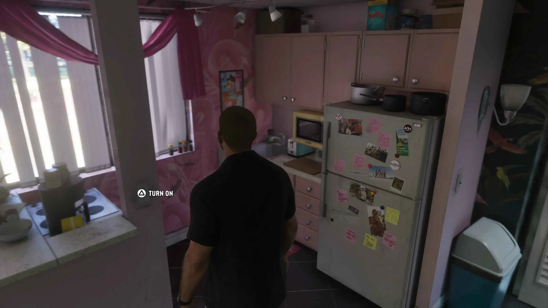 Jason stands in a pink apartment kitchen in GTA 6 with a Turn On button prompt displayed beside the counter.