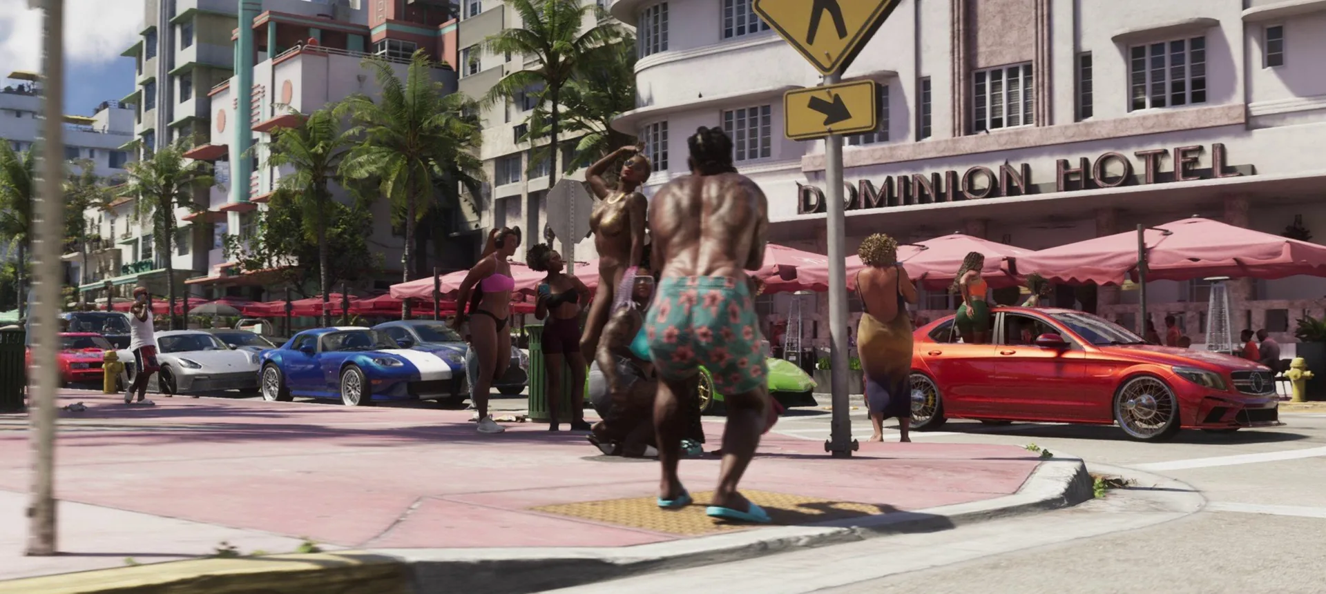 Pedestrians in swimwear cross a pink pavement past parked sports cars and cafe umbrellas outside the art deco Dominion Hotel in GTA 6