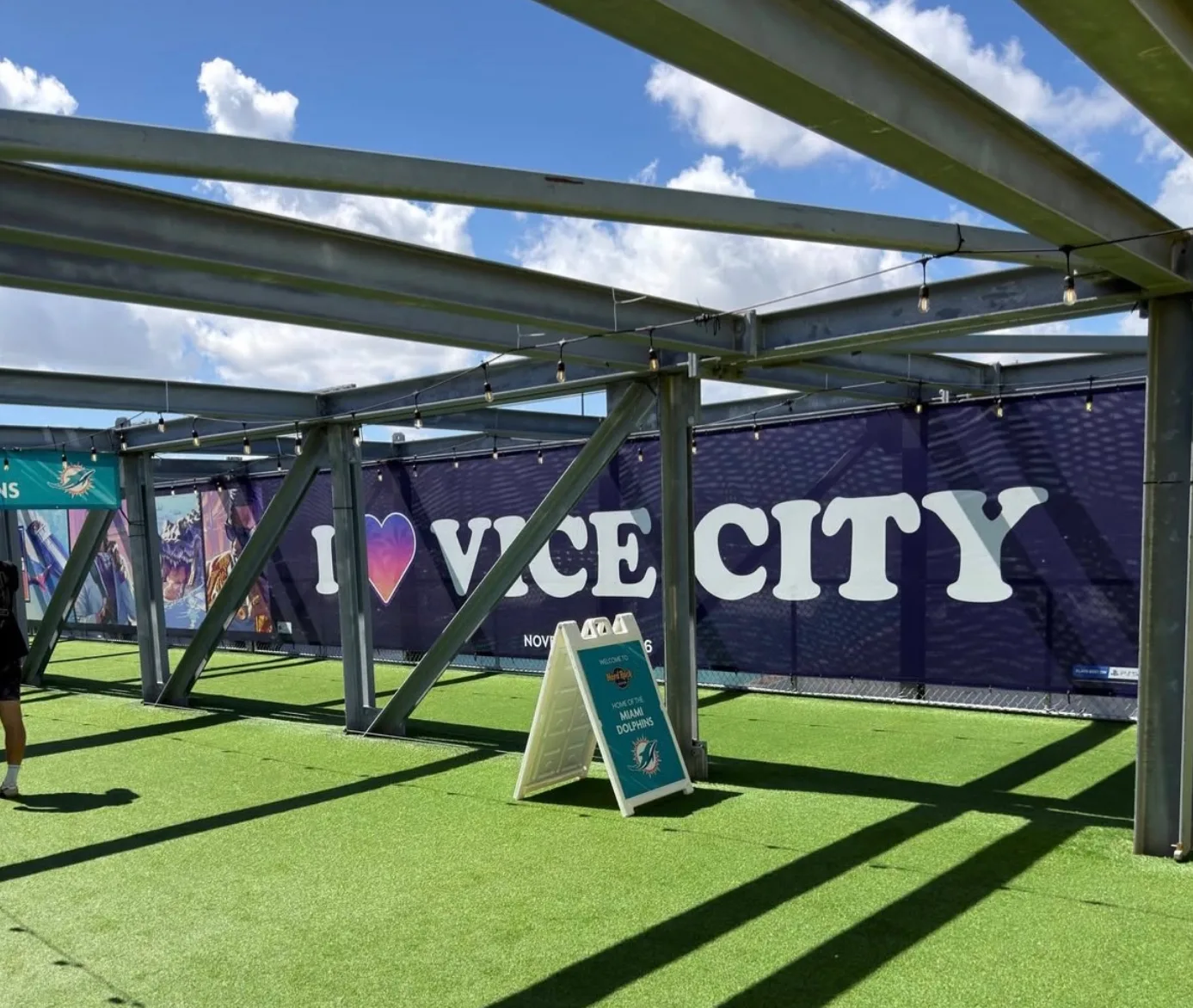 I Heart Vice City banner along the Hard Rock Stadium walkway with a Home of the Miami Dolphins sign on the turf
