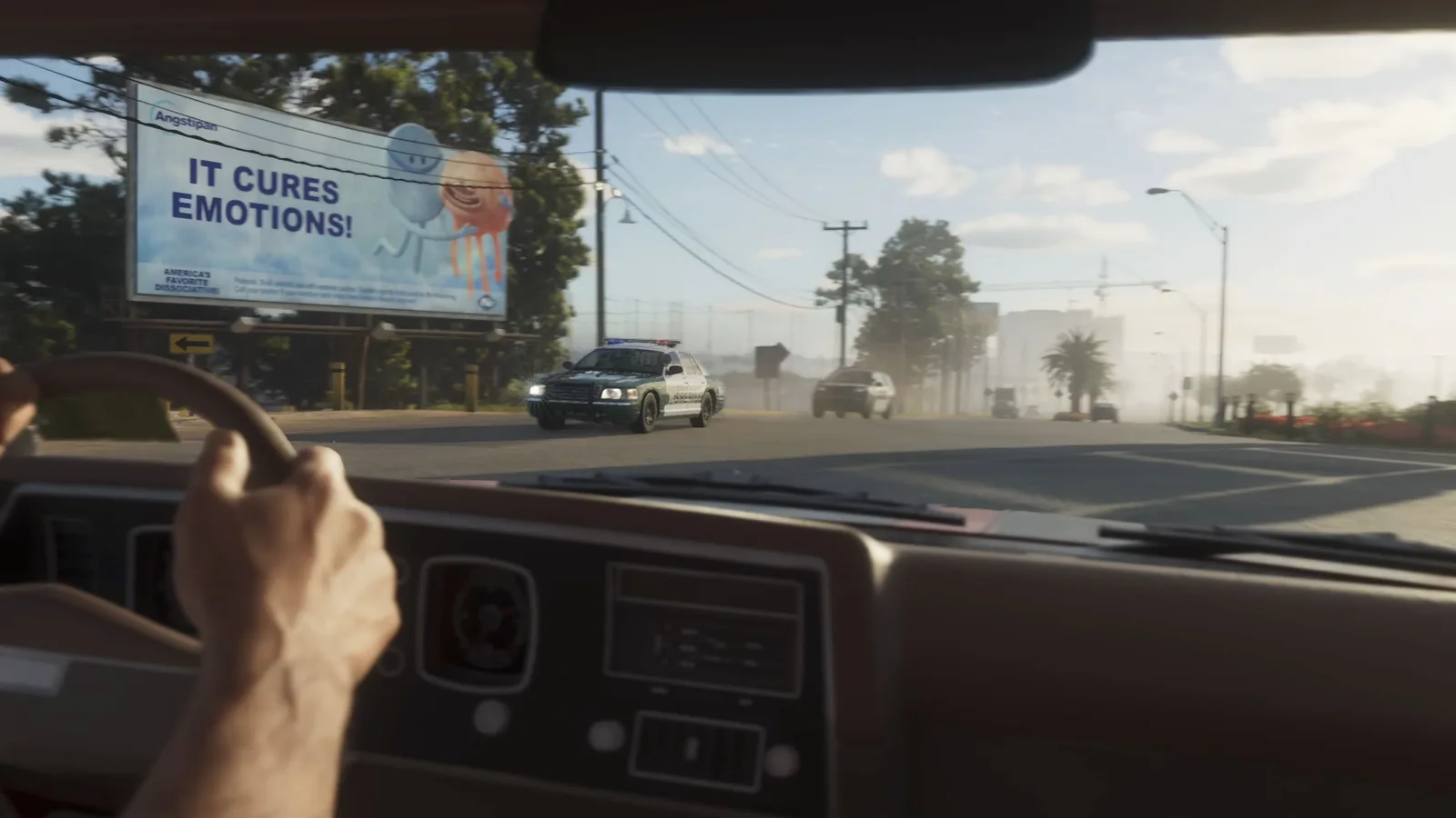 First person view from a rusted pickup driving past a billboard while a police car waits ahead on a Leonida road in GTA 6