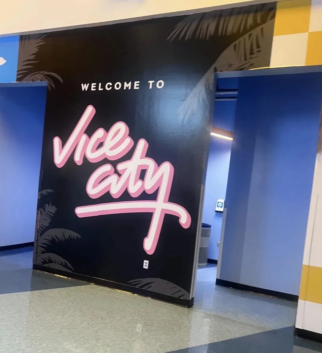 A Welcome to Vice City mural in pink script on a black wall inside the Kaseya Center