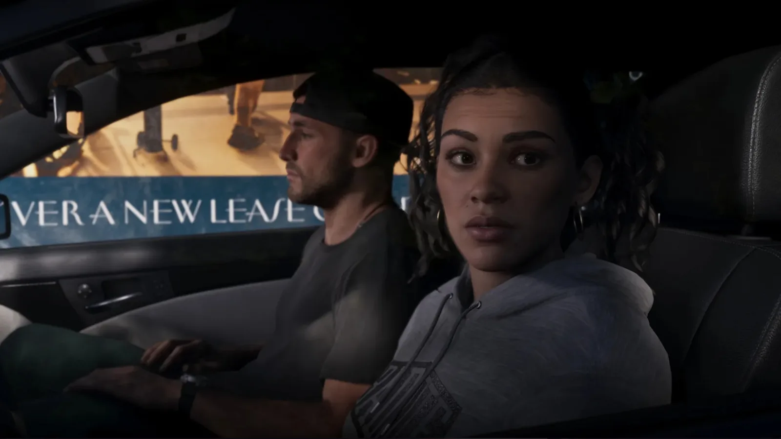Jason driving with Lucia in the passenger seat past an Over A New Leaf billboard in GTA 6