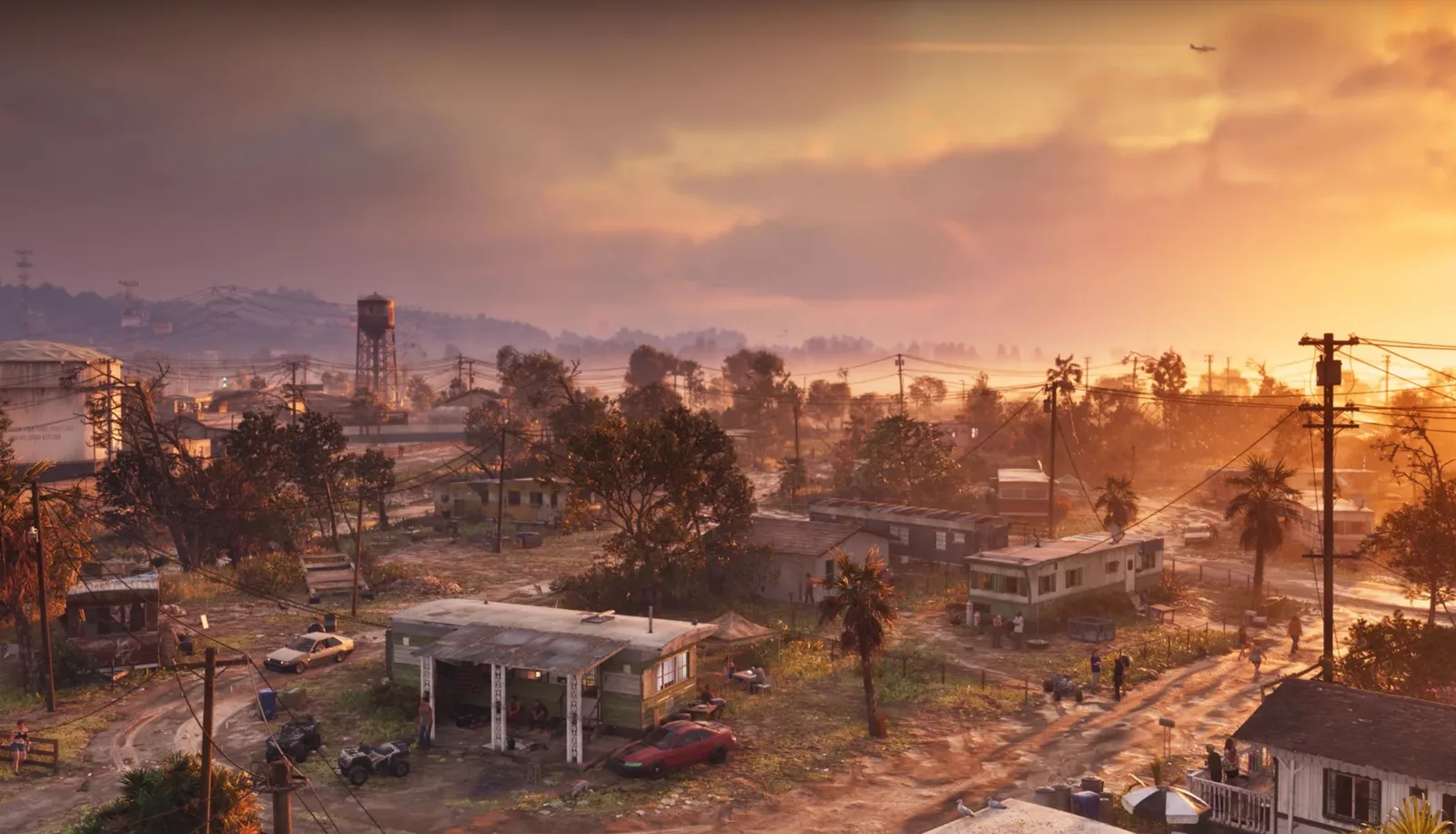 Sunset over a rundown Leonida town with trailer homes, power lines and a water tower in GTA 6