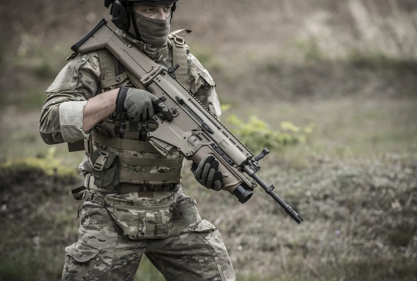Soldier in camouflage advancing with an FN SCAR rifle, the real-world basis for the GTA 6 SCAR Assault Rifle.